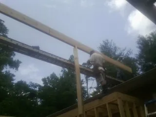 Carpenter setting a ridge beam over a new addition frame — Ice Dam Removal by Roofing Brothers in Farrell