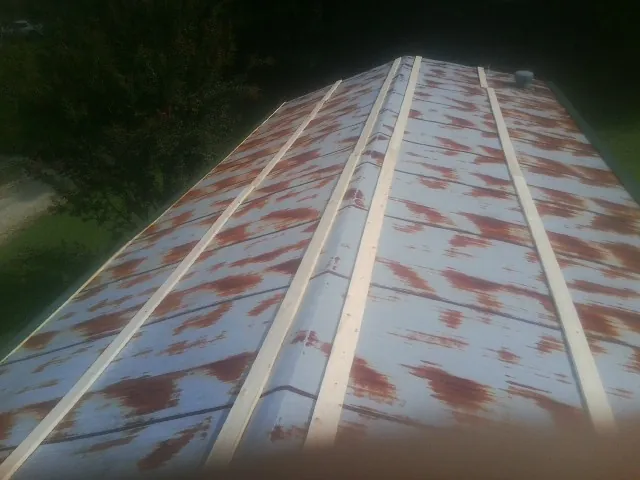 Rusted metal roof panels with new wood purlins before replacement — Storm Damage Roof Repair in Farrell by Roofing Brothers