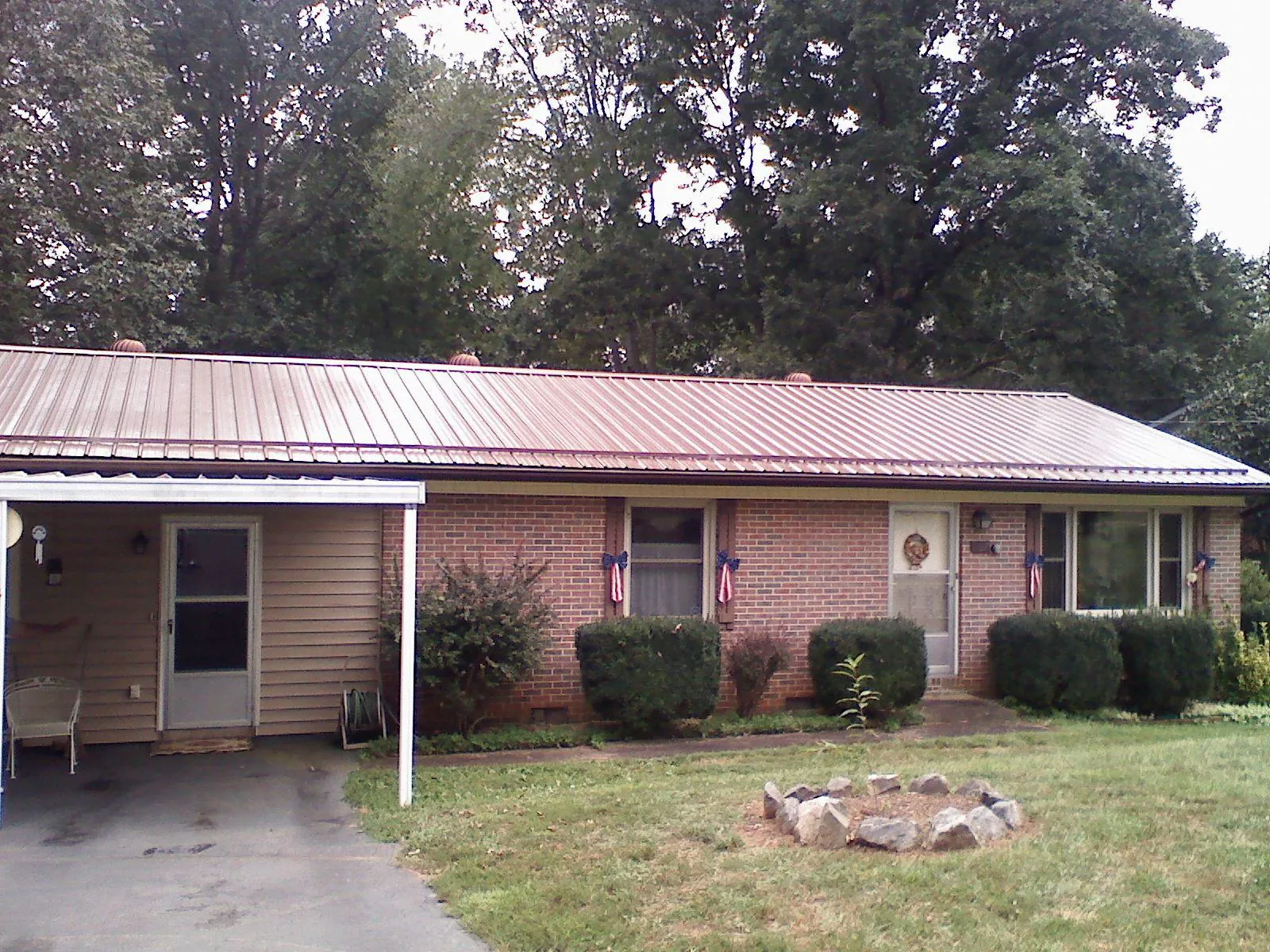 Bronze metal roof and carport on a brick ranch home — Roof Repair work by our crew in Farrell